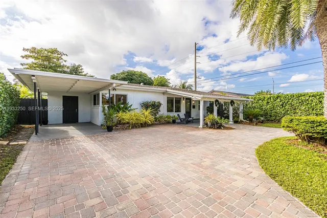 a view of a house with a yard and potted plants