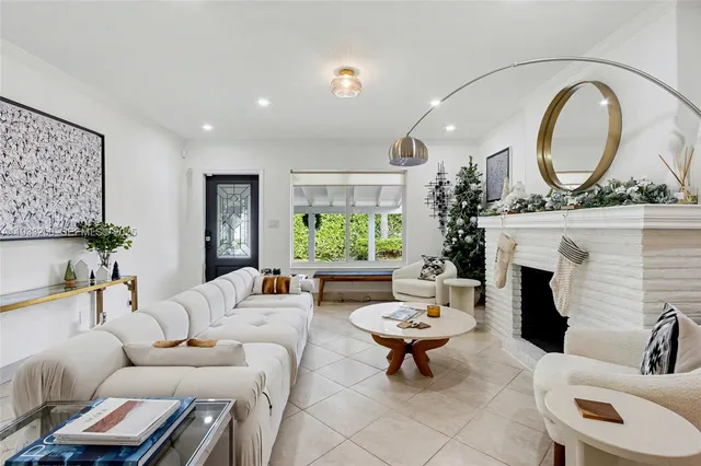 a living room with furniture a fireplace and a large window