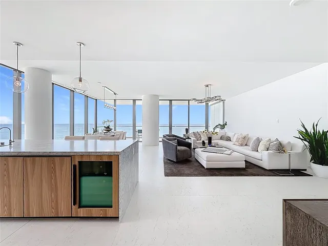 a living room with furniture chandelier and a large window
