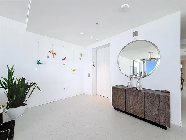 a living room with furniture and a dining table with potted plants
