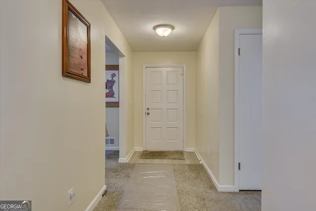 an empty room with mirror and door