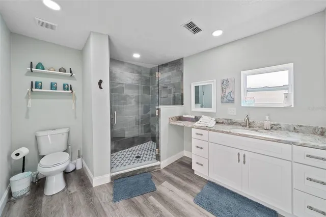 a bathroom with a double vanity sink toilet and shower