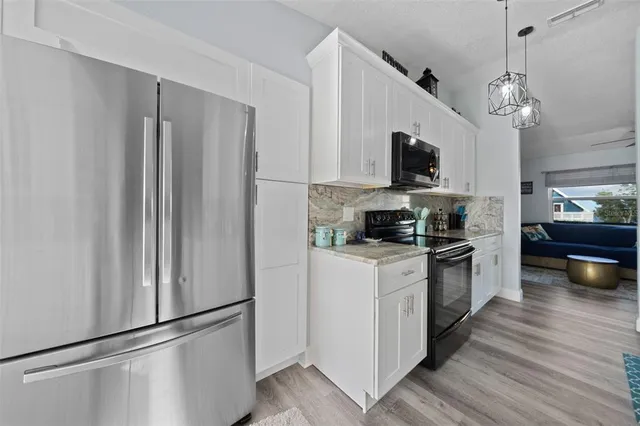 a kitchen with stainless steel appliances a refrigerator and a stove top oven