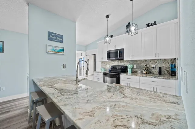 a kitchen with kitchen island a white counter top space cabinets and appliances