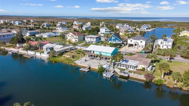 an aerial view of ocean and residential houses with outdoor space