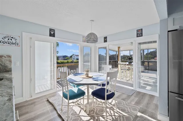 a dining room with wooden floor and large windows