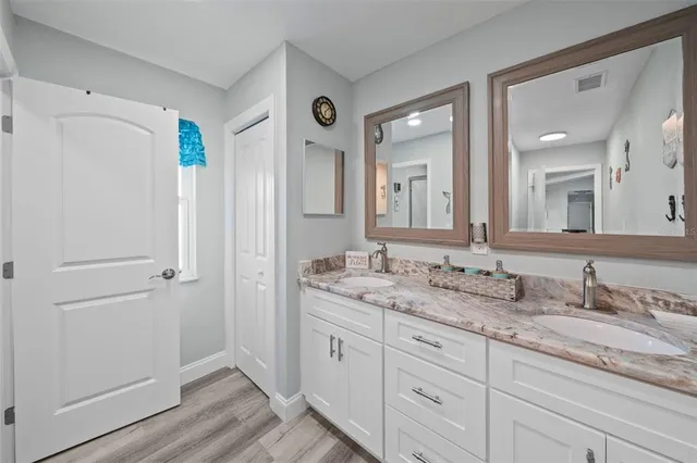 a spacious bathroom with a granite countertop sink and a mirror