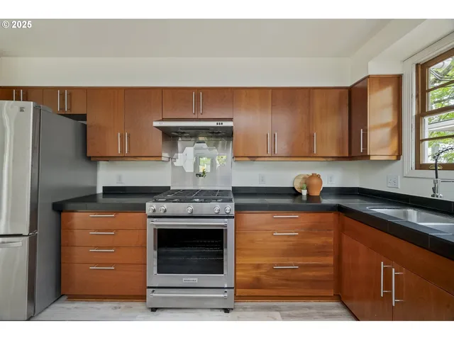a kitchen with stainless steel appliances granite countertop a stove and a refrigerator