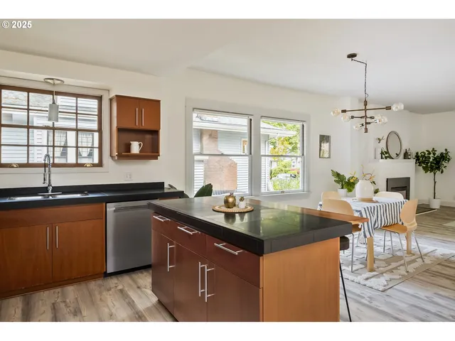a kitchen with granite countertop a sink window and cabinets