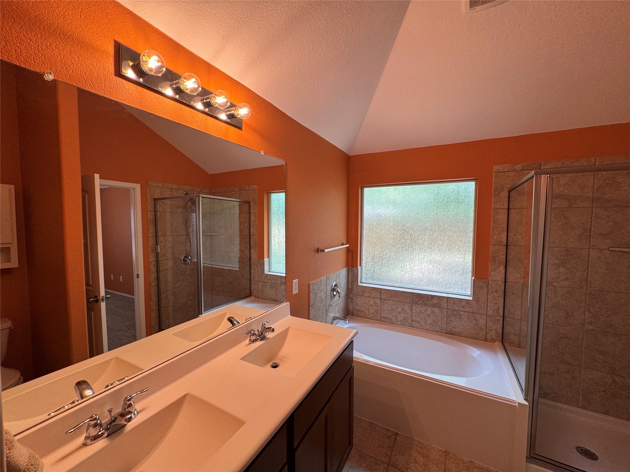 112 Eagle Owl Loop Leander, TX 78641 - Photo 12 of 34 Dual vanity with integrated sinks, a built-in garden tub, and a separate glass-enclosed shower