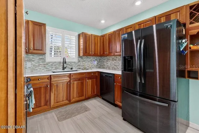 a kitchen with stainless steel appliances granite countertop a refrigerator and a sink
