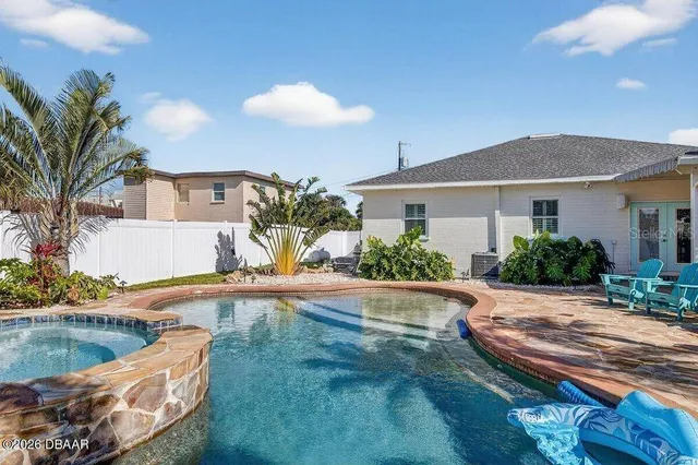 a view of a house with backyard and sitting area