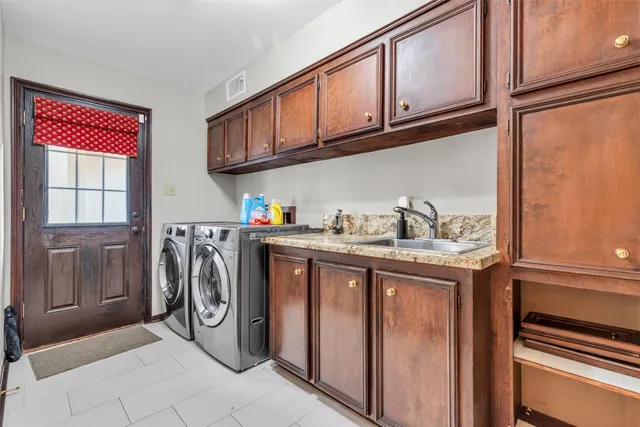 a bathroom with granite countertop white cabinets and a sink