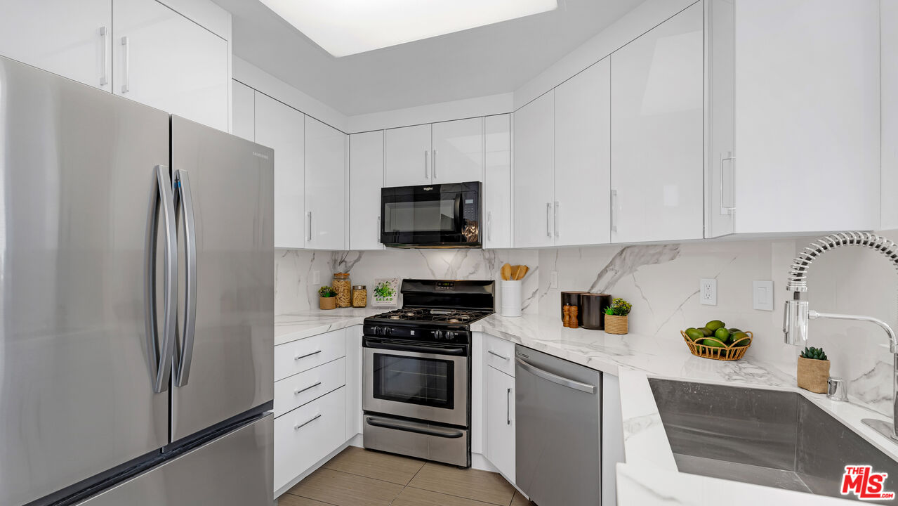 19431 Rue De Valore, Unit 41M Foothill Ranch, CA 92610 - Photo 8 of 23 a kitchen with refrigerator a microwave a stove and cabinets