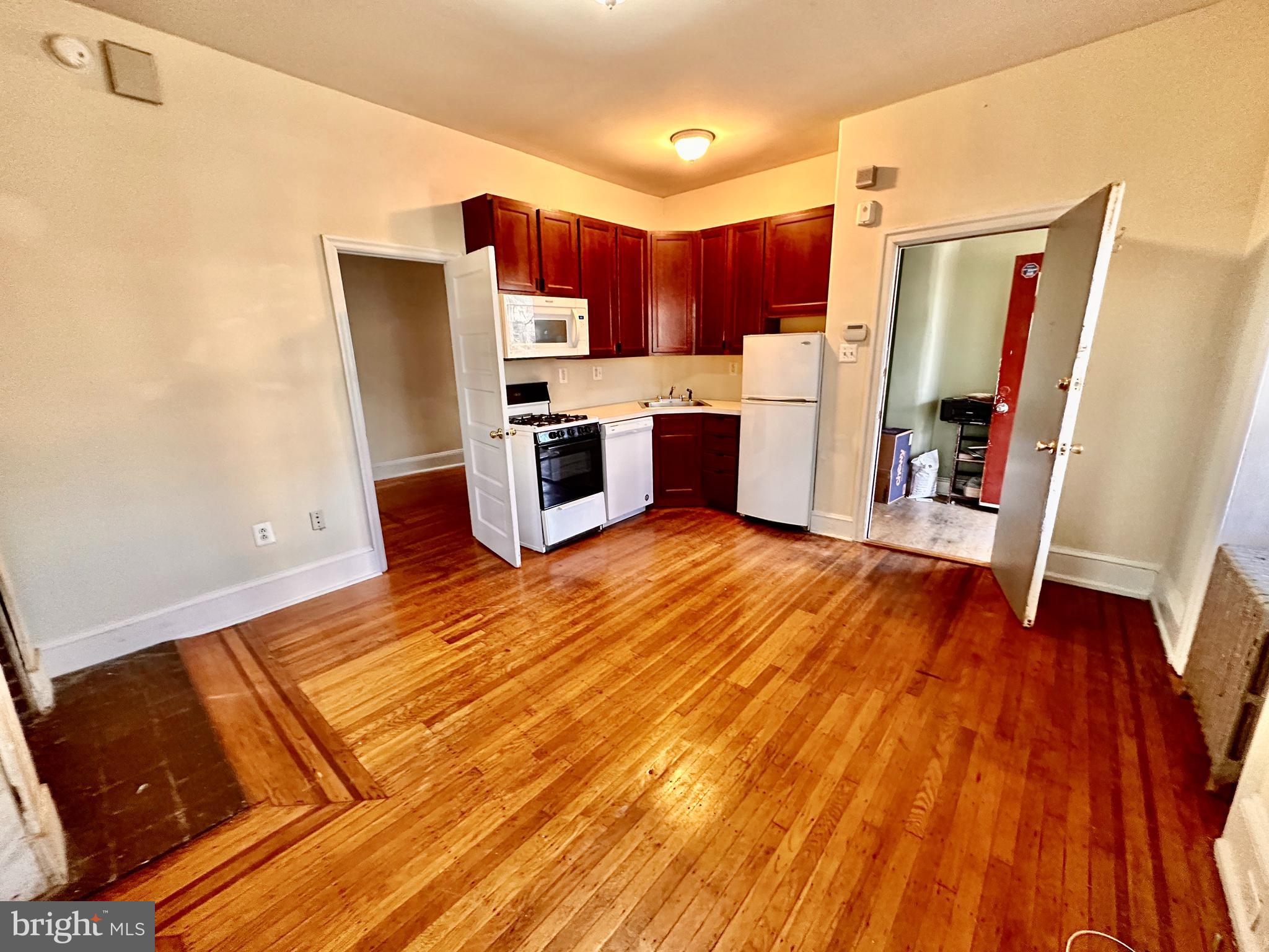 a kitchen with stainless steel appliances a refrigerator and wooden floor