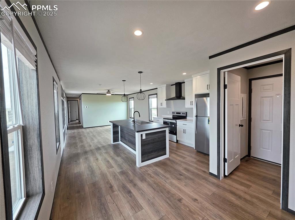 6685 Ramah Highway Yoder, CO 80864 - Photo 12 of 30 a kitchen with stainless steel appliances wooden floor and large window