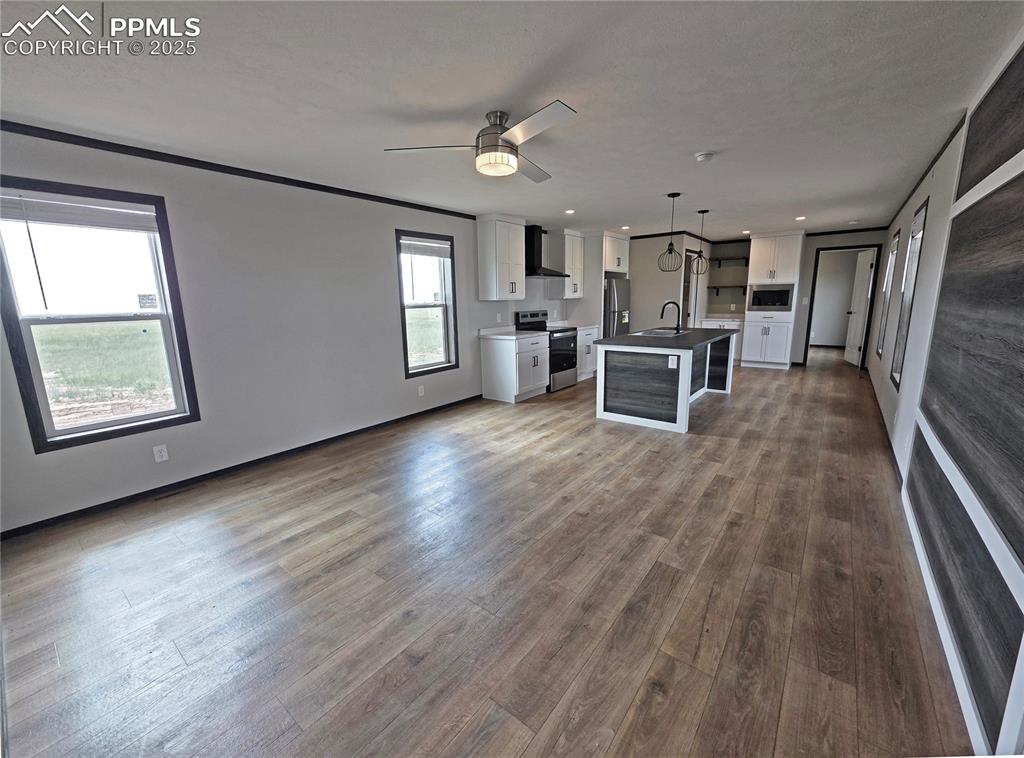 6685 Ramah Highway Yoder, CO 80864 - Photo 7 of 30 wooden floor fireplace and windows in an empty room