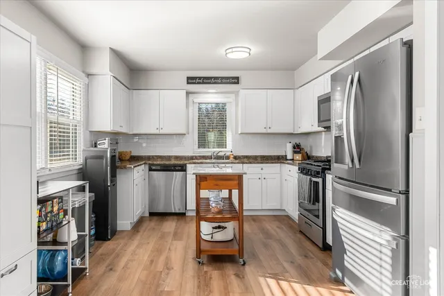 a kitchen with a refrigerator wooden floor and a window