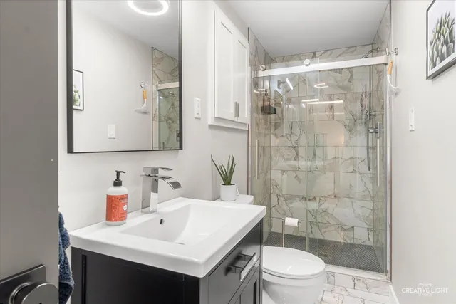 a bathroom with a sink toilet a mirror and shower