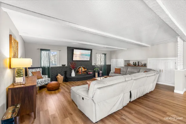 a living room with furniture and a wooden floor