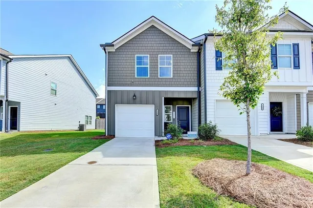 a front view of a house with a yard and garage