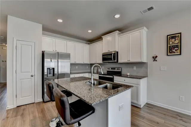 a kitchen with stainless steel appliances a microwave sink refrigerator and cabinets