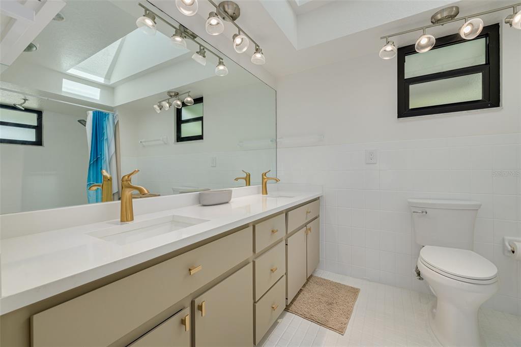 5531 Manatee Point Drive New Port Richey, FL 34652 - Photo 36 of 61 a spacious bathroom with a granite countertop sink a toilet and a mirror