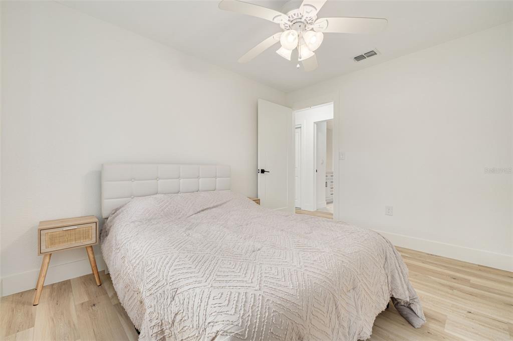 5531 Manatee Point Drive New Port Richey, FL 34652 - Photo 42 of 61 a large bed sitting in a spacious bedroom and a chandelier