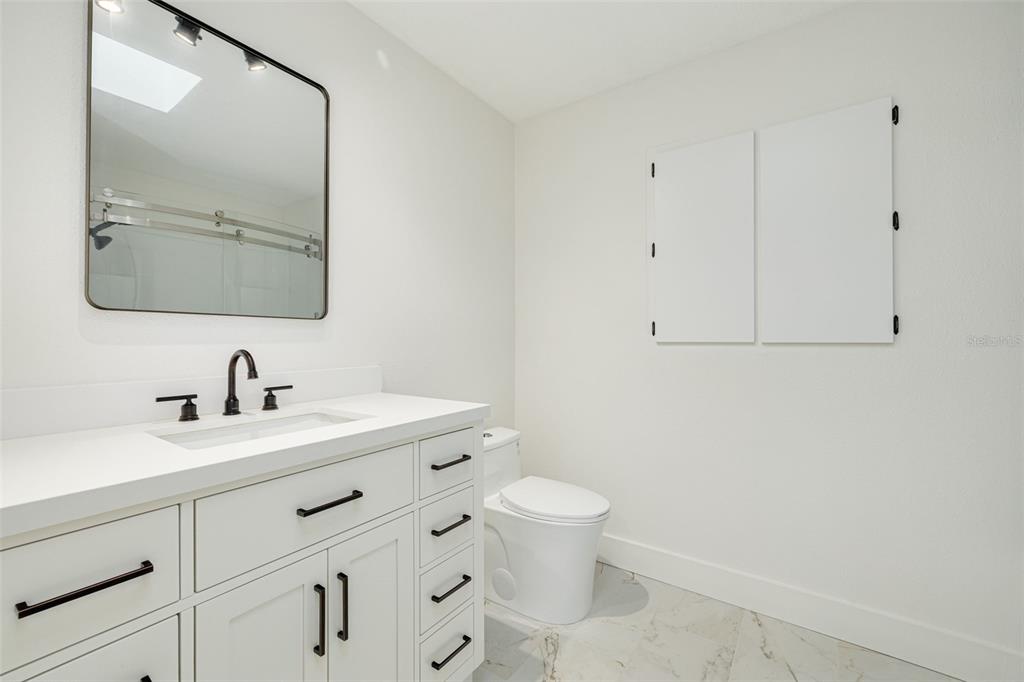 5531 Manatee Point Drive New Port Richey, FL 34652 - Photo 43 of 61 a bathroom with a granite countertop sink vanity mirror and toilet