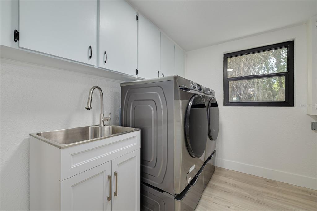 5531 Manatee Point Drive New Port Richey, FL 34652 - Photo 48 of 61 a utility room with cabinets washer and dryer