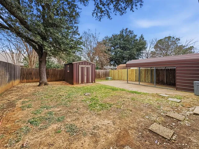 a backyard of a house with a large tree