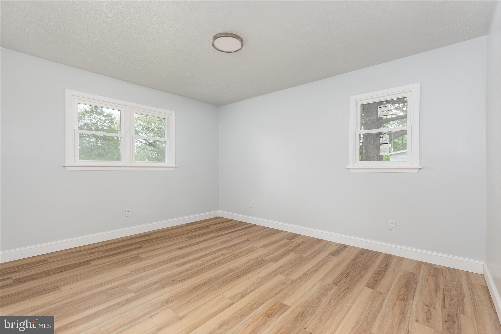 64 Shickle Lane Inwood, WV 25428 - Photo 16 of 42 an empty room with wooden floor and windows