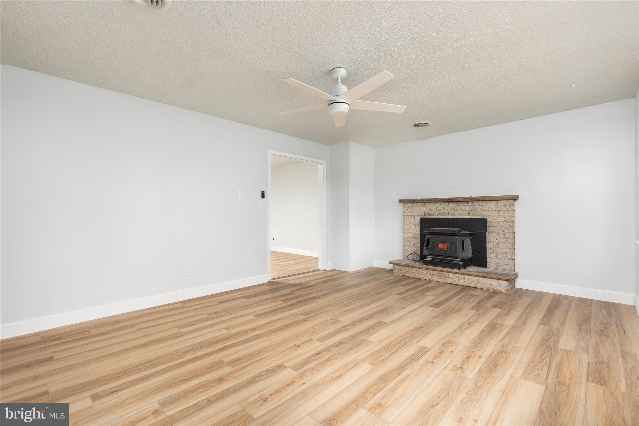 64 Shickle Lane Inwood, WV 25428 - Photo 3 of 42 a view of empty room with wooden floor and fireplace