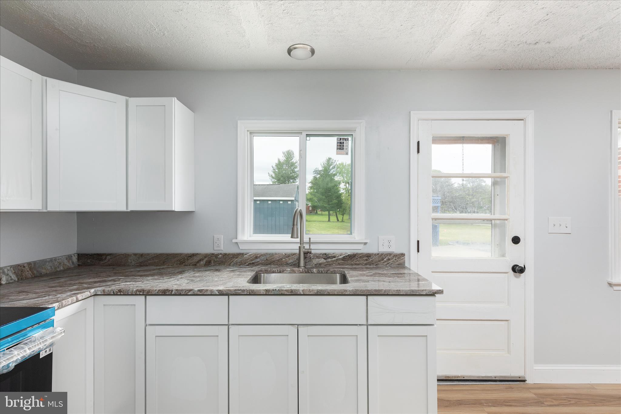 64 Shickle Lane Inwood, WV 25428 - Photo 10 of 42 a kitchen with granite countertop white cabinets and a window