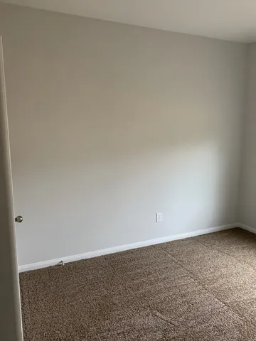 an empty room with closet and mirror