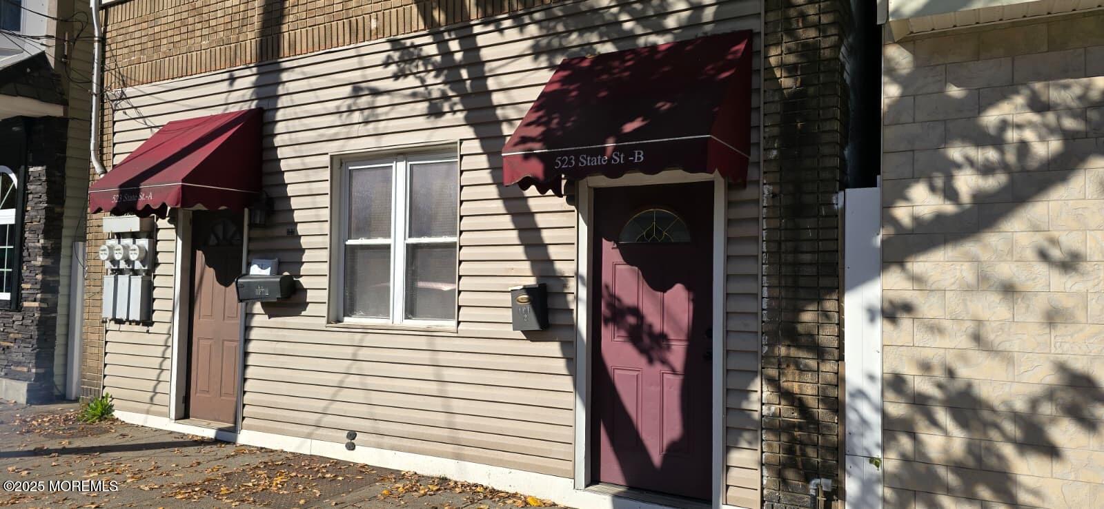 a view of a house with a door and a tree