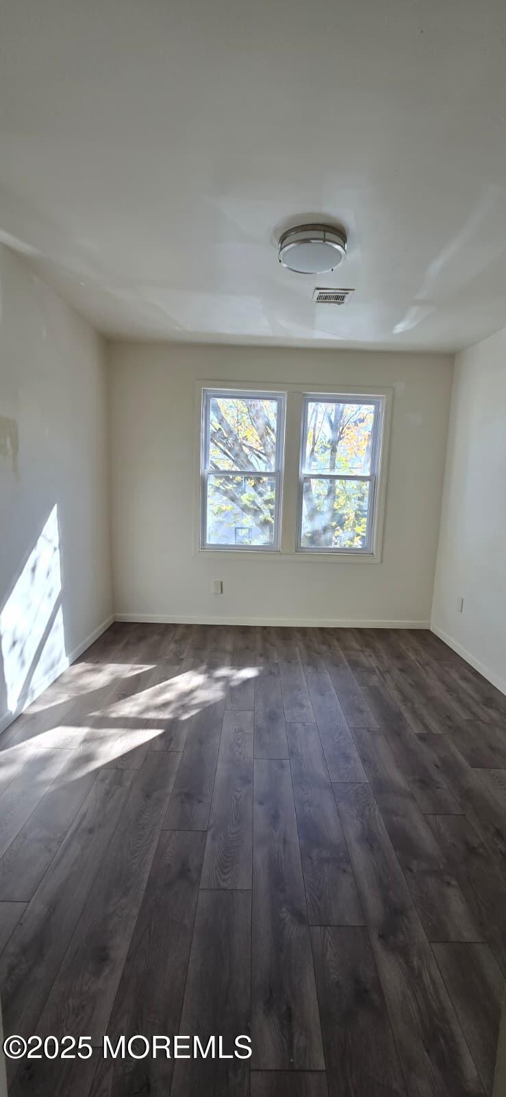 523 State Street Perth Amboy, NJ 08861 - Photo 6 of 12 an empty room with wooden floor and windows