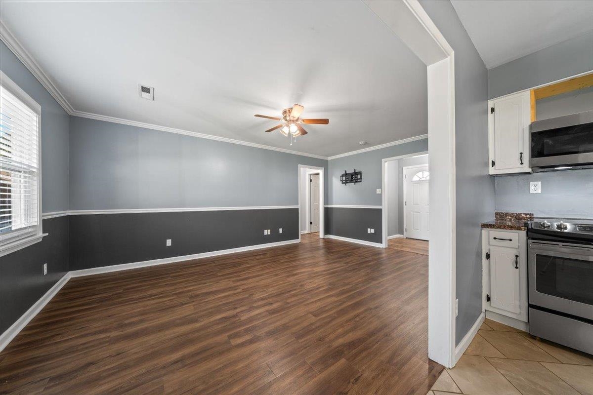 9496 Holly Grove Road Brighton, TN 38011 - Photo 9 of 29 Kitchen featuring white cabinetry, appliances with stainless steel finishes, a ceiling fan, dark wood-type flooring, and crown molding