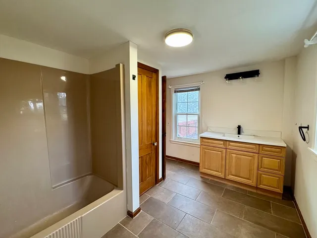 a large bathroom with a bathtub and a sink