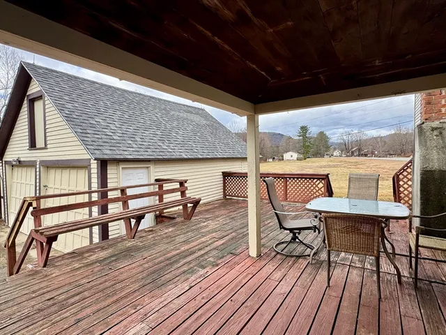a view of a balcony with chairs and wooden floor