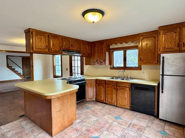 a kitchen with stainless steel appliances granite countertop a sink stove and refrigerator