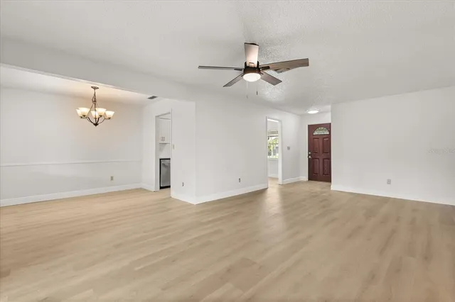 an empty room with fan and windows