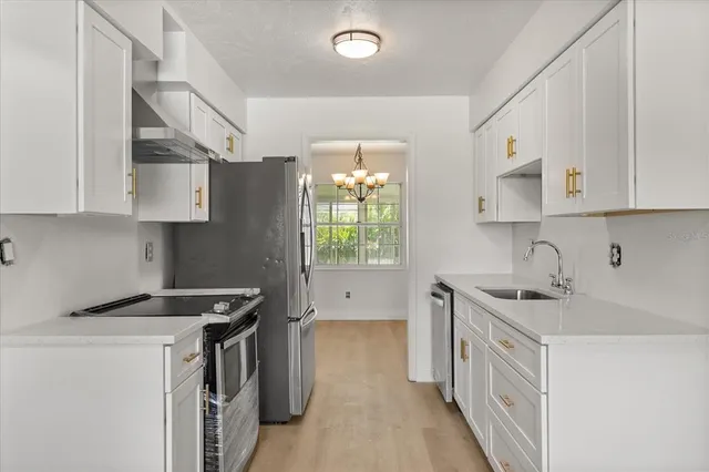 a kitchen with stainless steel appliances granite countertop a refrigerator and a stove