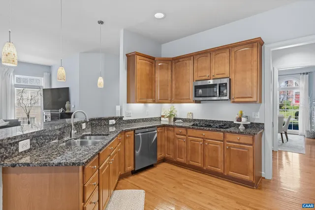 a kitchen with stainless steel appliances granite countertop a refrigerator and a sink