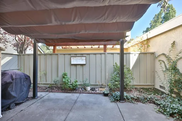 a backyard with potted plants and a table and chair