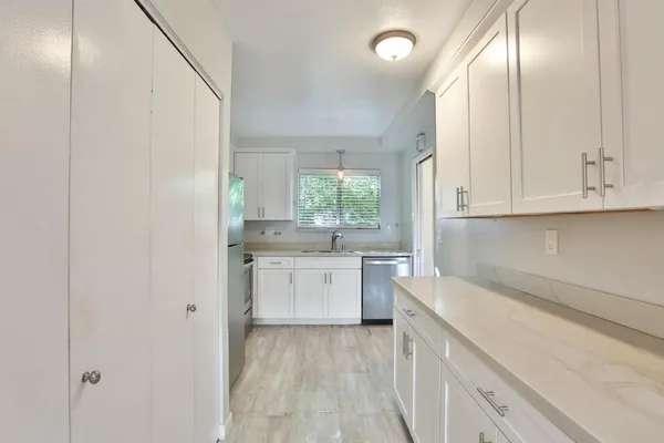 a kitchen with granite countertop white cabinets and white appliances