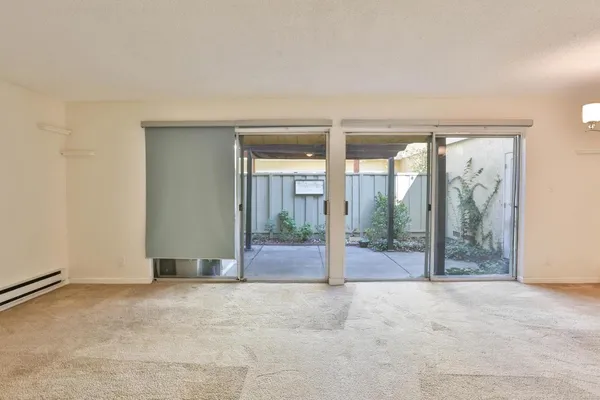 an empty room with floor to ceiling windows and yard