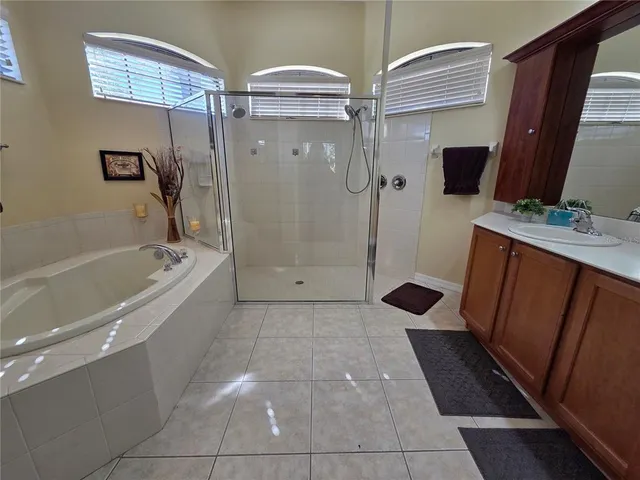 a spacious bathroom with a shower sink and mirror