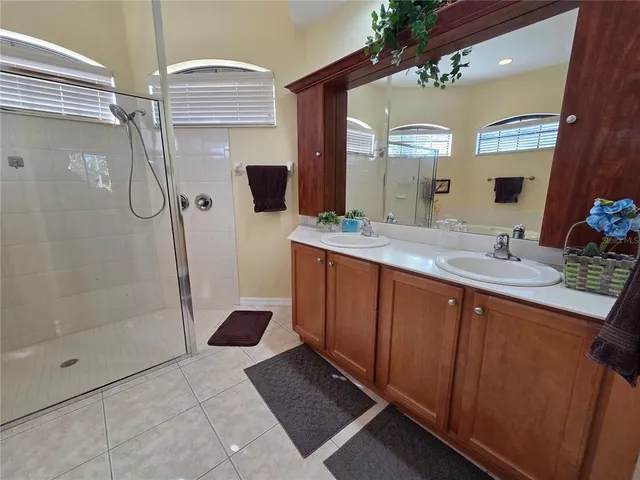 a bathroom with a sink a toilet a mirror and painting on the wall