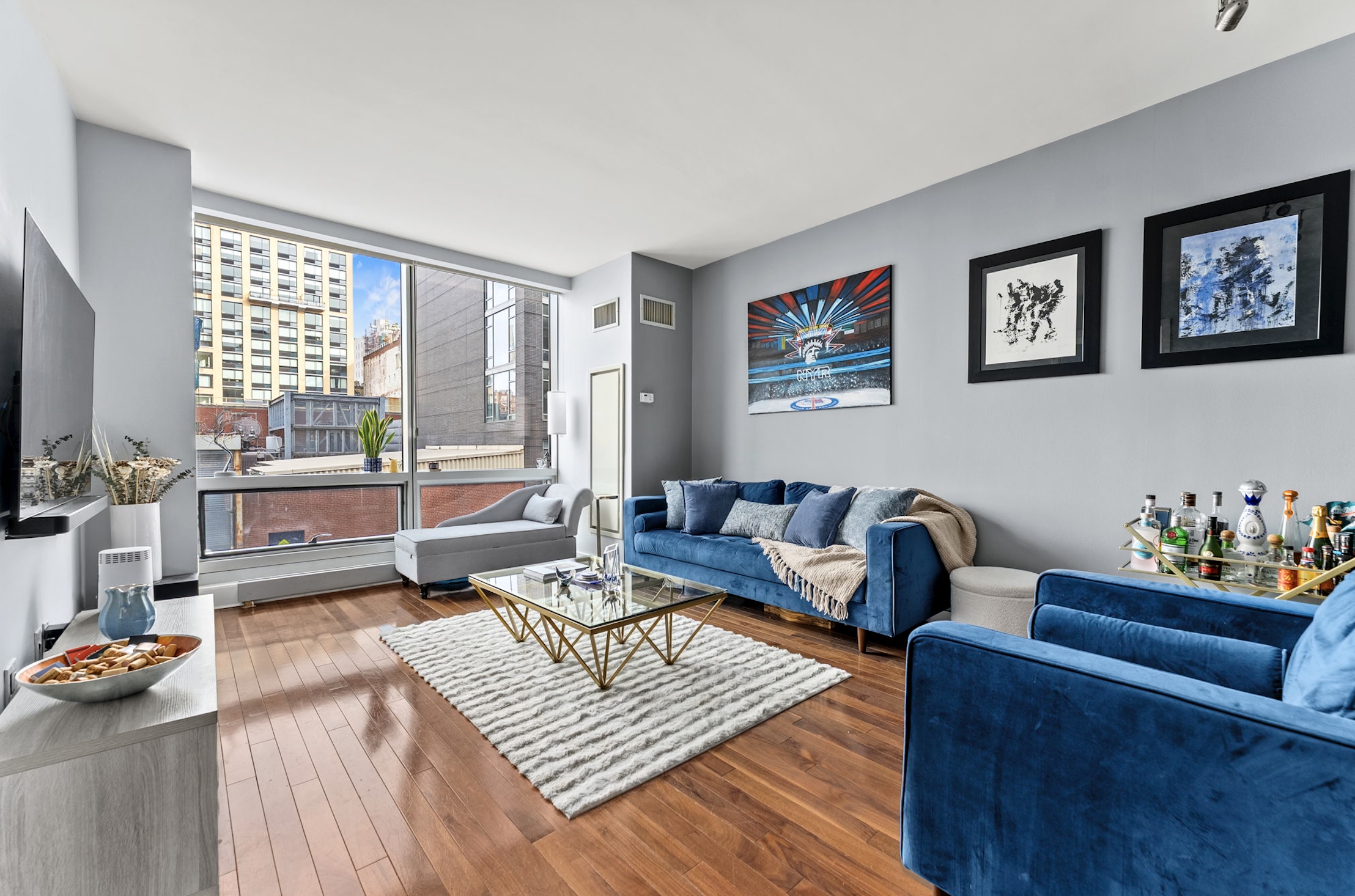 166 West 18th Street, Unit 2D Manhattan, NY 10011 - Photo 2 of 17 a living room with furniture and a flat screen tv